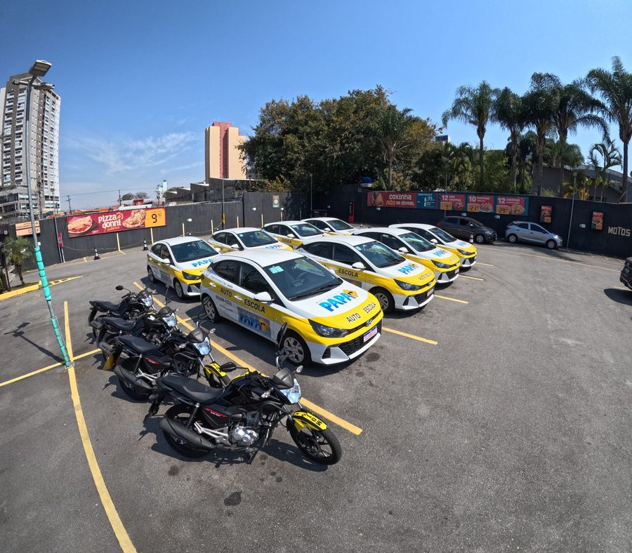Carros HB20 0km e motos da Auto Escola PAPA estacionados no pátio